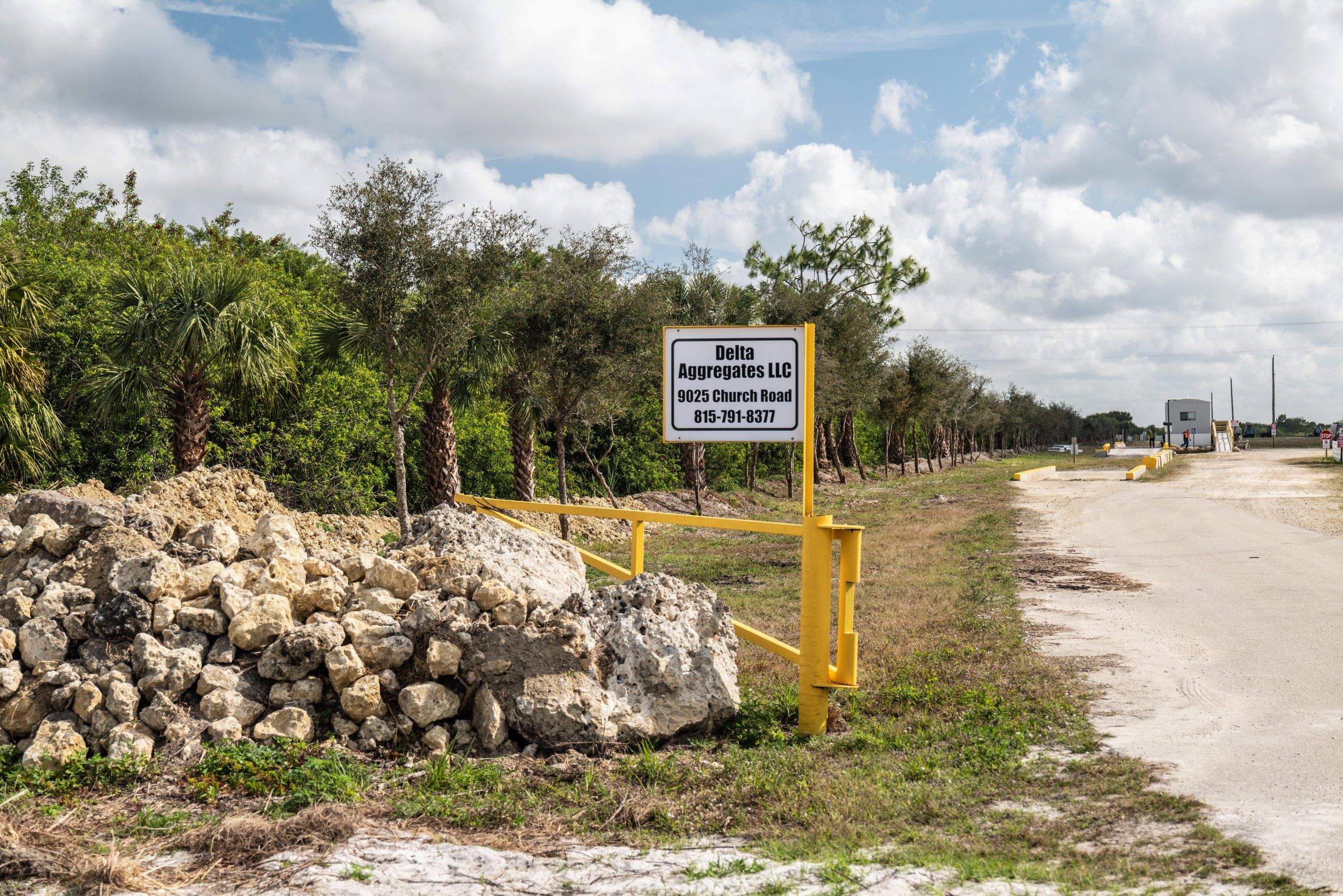 Entrance to Delta Aggregate facility on South Church Road in Immokalee, Florida, with limerock stockpile visible along the left side of the drive.